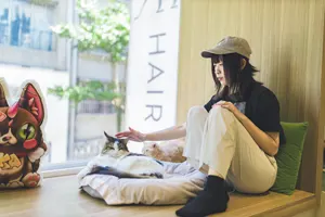 フリー写真 猫カフェの猫を撫でる台湾人女性
