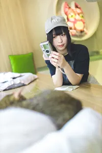 フリー写真 デジカメを縦に構えて猫の写真を撮る台湾人女性