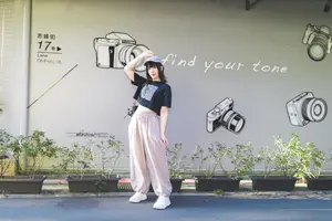 フリー写真 カメラが描かれた壁の前に立つ台湾人女性