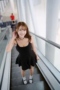 フリー写真 黒のミニワンピース姿でエスカレーターに乗る台湾人女性