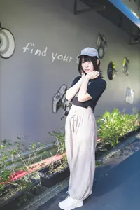 フリー写真 カメラが描かれた壁と顎に手を当てた台湾人女性