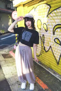 フリー写真 キャップのつばに手を当ててシャッターの前に立つ台湾人女性