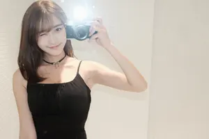 フリー写真 フラッシュをたいたカメラを持つ台湾人女性