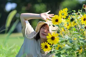 フリー写真 ヒマワリの花と手をかざす日本人女性