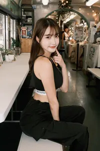 フリー写真 顎に指を当ててベンチに座る台湾人女性