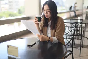 フリー写真 カフェで書類を見ている日本人女性