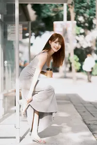 フリー写真 バス停で片足を上げて立つロングワンピ姿の台湾人女性