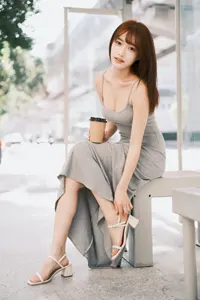 フリー写真 サンダルストラップを触りながらベンチに座る台湾人女性