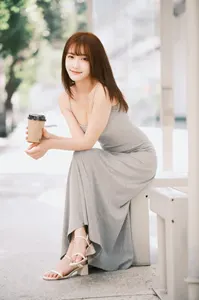 フリー写真 膝に肘をついてベンチに座る台湾人女性