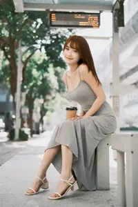 フリー写真 ロングワンピース姿でバス停のベンチに座る台湾人女性