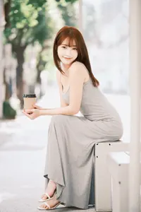フリー写真 コーヒーを持ってバス停のベンチに座る台湾人女性