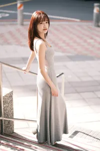フリー写真 手すりに手をついて階段に立つグレーのワンピース姿の台湾人女性
