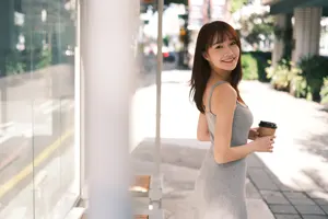 フリー写真 コーヒーが入った紙コップを持ってバス停に立つキャミワンピ姿の台湾人女性