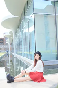 フリー写真 池の前に足を伸ばして座るニットとミニスカ姿の台湾人女性